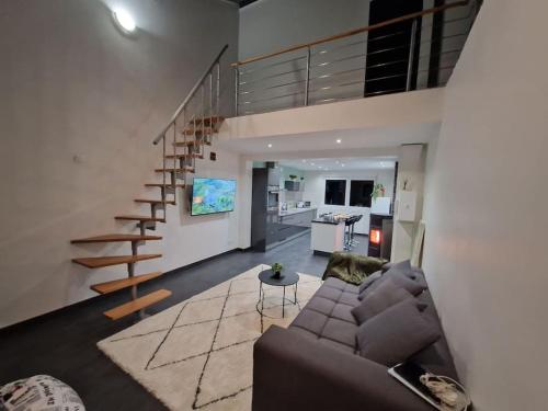 sala de estar con sofá y escalera de caracol en Duplex-Cocon-Proximité - Piscines Thermales -Sauna, en Hombourg-Haut