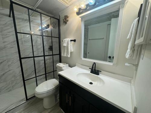 Un baño con lavabo, inodoro y espejo. en Beautiful 2BD right on the beach in Okaloosa Island, en Fort Walton Beach