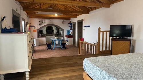 a bedroom with a bed and a living room with a kitchen at Casa da Lapa in Angra do Heroísmo