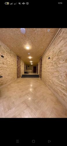 een grote kamer met een houten vloer en een bakstenen muur bij Santa Maria in Marsa Matruh