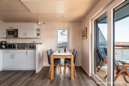 a kitchen and dining room with a table and chairs at Hausboot Harmonie in Stralsund