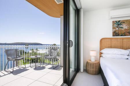 1 dormitorio con 1 cama y balcón con vistas. en Lavish Coastal 2-Bed with Stunning Ocean Views, en Batemans Bay