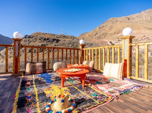 - une table et des chaises sur une terrasse offrant une vue sur la montagne dans l'établissement Riad Atlas Dreams Imlil, à Imlil