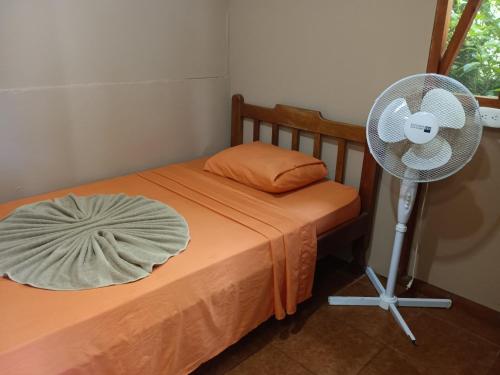 a bedroom with a fan next to a bed at Jacobin Hostel & Cabins in Drake