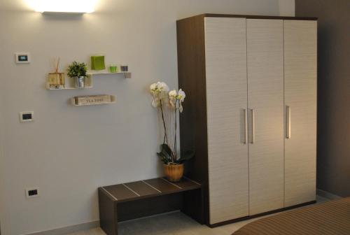 a bedroom with a large white wardrobe and a bench at Anda e Rianda in Campi Bisenzio