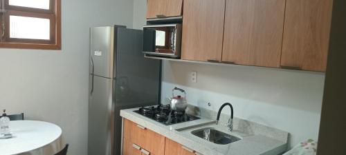 a kitchen with a sink and a refrigerator at Casa da Marilú in Florianópolis