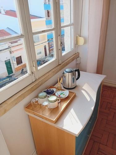 - un comptoir de cuisine avec une bouilloire et des tasses ainsi qu'une fenêtre dans l'établissement Quarto Duplo Baixa de Portimao Junto à Estação Ferroviária, à Portimão