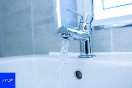 a sink with water coming out of a faucet at 2ndHomeStays-Walsall- A Charming 3-Bed Home with Landscape View - Suitable for Contractors and Families -Large Parking for 3 Vans - Sleeps 8 - 7 mins to J10 M6 and 21 mins to Birmingham in Bloxwich