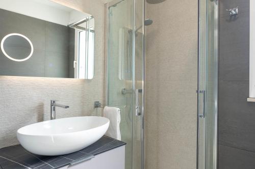 a bathroom with a sink and a glass shower at Residence LeoMare in Martinsicuro
