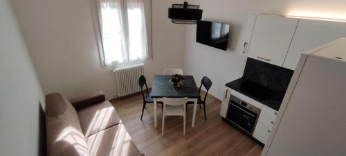 una pequeña cocina con mesa y sillas en una habitación en BOLOESTHOUSE en Bolonia