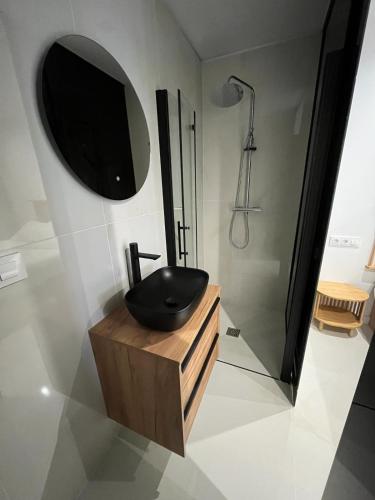 a bathroom with a sink and a shower and a mirror at Suite PLAYAMAR con jacuzzi in Torremolinos