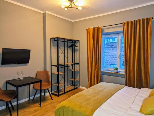 una camera con letto, scrivania e TV di Bella Luna Luxury Suites - Chic Residence in Historic Square a Varsavia