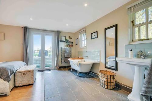 a bathroom with a tub and a sink and a bed at Home sweet home in Little Wymondley