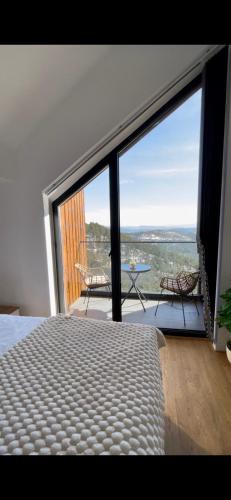 a bedroom with a bed and a large glass window at Divcibare Vrh 26 in Divčibare
