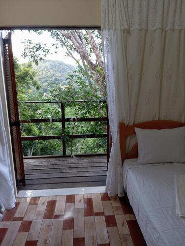 a bedroom with a bed and a large window at Flor da serra in Santo Antônio do Pinhal