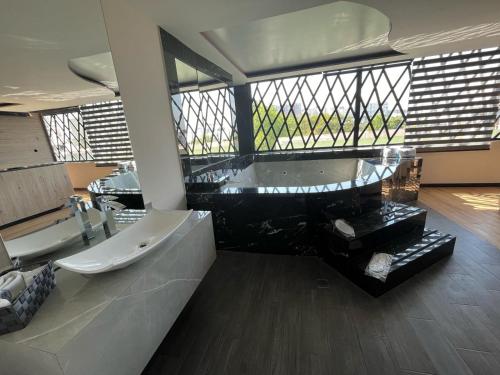 a large bathroom with a tub and a sink at Hotel City Lights in Mexico City