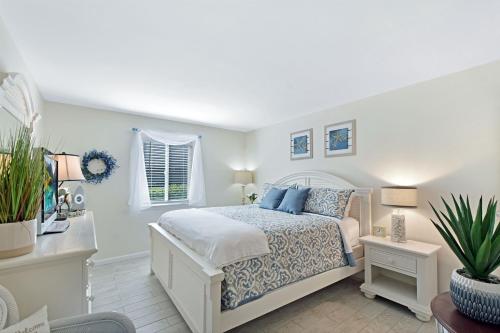 a bedroom with a white bed with blue pillows at Ocean Walk E-5 in Saint Simons Island