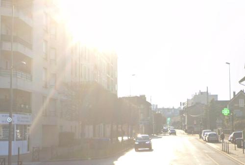 Une voiture qui descend dans une rue urbaine avec des bâtiments dans l'établissement Pret à usage & Commodat Résidence Foch Saint-Louis - 30 nuitées minimum - Salarié mobilité ou étudiant stagiaire, à Poissy