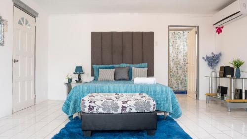 a bedroom with a large bed with a blue blanket at Rowy's appartement in Willemstad