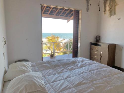 a bedroom with a bed and a view of the ocean at Casa Tío Luiz in Aquiraz