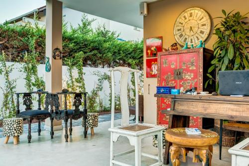 a room with chairs and a piano and a clock at Villa Kore Cesme in Çeşme