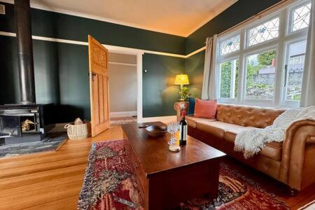 a living room with a couch and a large window at Renovated Cottage Near Cataract Gorge Launceston in Royal Park
