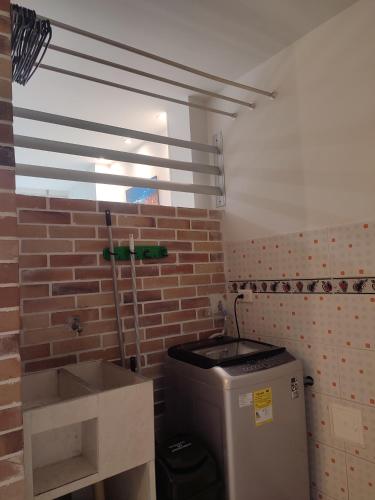 baño con pared de ladrillo y lavamanos en 201-Cómodo y moderno apartamento de 2 habitaciones en la mejor zona céntrica de ibagué, en Ibagué