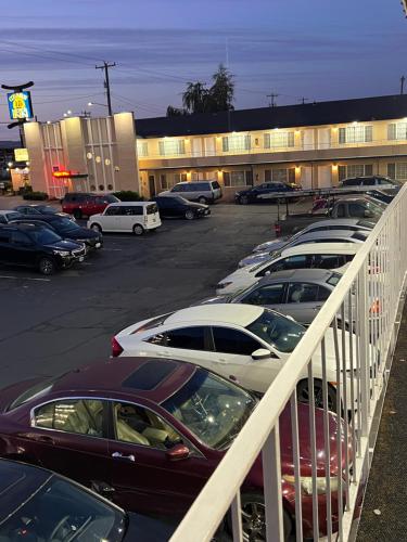 a parking lot with cars parked in front of a building at Columbus Motor Inn in Seattle