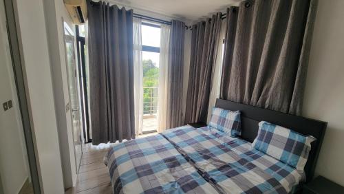 um quarto com uma cama e uma grande janela em Acasia Luxury Home Cantonment em Acra