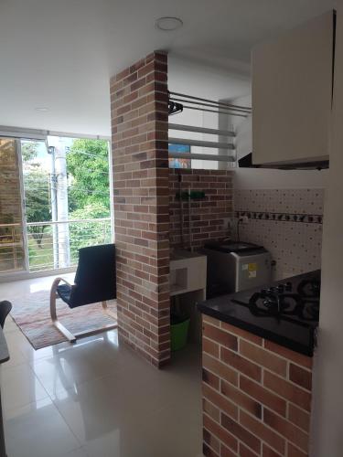 a kitchen with a brick wall and a stove at 201-Cómodo y moderno apartamento de 2 habitaciones en la mejor zona céntrica de ibagué in Ibagué