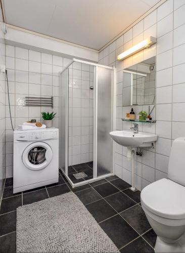 a bathroom with a washing machine and a sink at God søvn in Lillestrøm