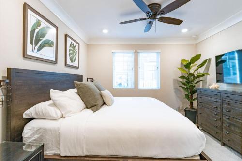 a bedroom with a white bed and a ceiling fan at Pristine and Luxe, Steps to Mission Beach and Bay! in San Diego