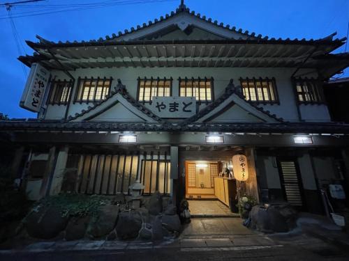a building with a sign on the front of it at night at Kanko Ryokan Yamato in Ikuma