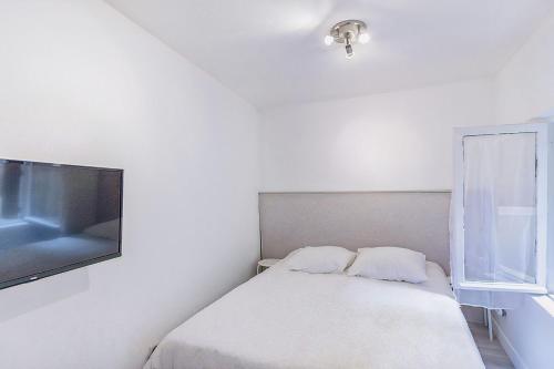 une chambre avec un lit et une télévision à écran plat dans l'établissement Petit Nid Douillet in the Old Port, à Marseille