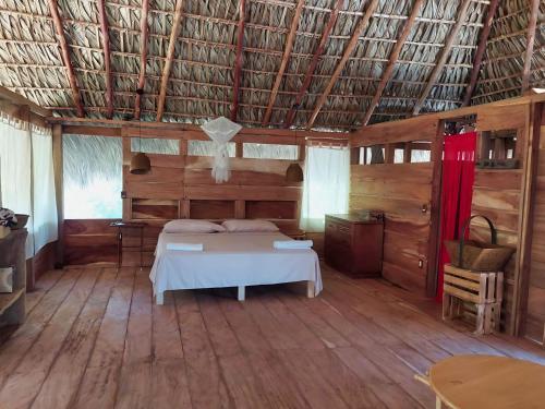 a bedroom with a bed in a room with wooden floors at Cabañas Casa de Agua in Boca del cielo