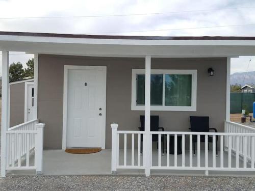 a small house with a white door and a porch at Sun Cabin #2 Pahrump in Pahrump