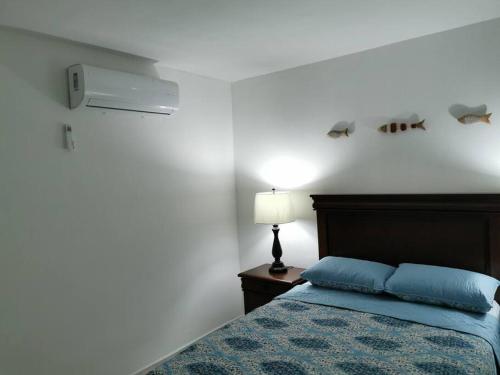 a bedroom with a bed with blue sheets and a lamp at Excelente apto muy cerca de la playa 202 in Mazatlán