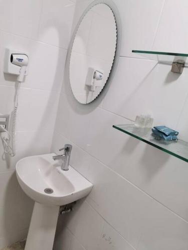a white bathroom with a sink and a mirror at Excelente apto muy cerca de la playa 202 in Mazatlán