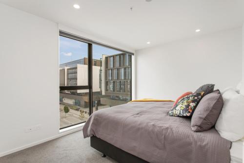 a bedroom with a bed and a large window at Central City Luxury Apartment stunning views sunny in Christchurch