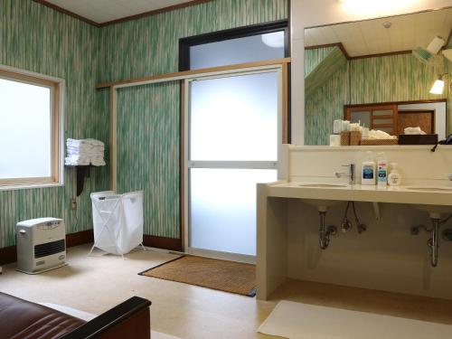 a bathroom with a sink and a mirror at Kanko Ryokan Yamato in Ikuma