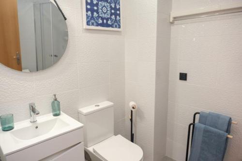 a bathroom with a toilet and a sink and a mirror at Beach Glove Ericeira II in Ericeira