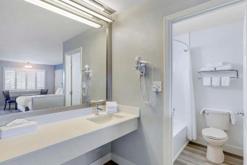 a bathroom with a sink and a toilet and a mirror at Best Western Space Age Lodge in Gila Bend