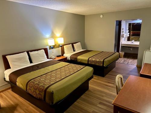 um quarto de hotel com duas camas e uma mesa em Thunderbird Motor Inn em Baraboo