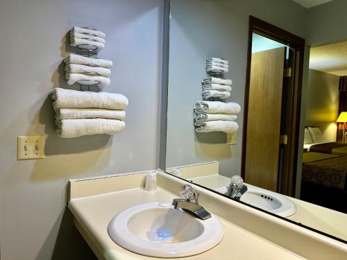 uma casa de banho com lavatório, espelho e toalhas em Thunderbird Motor Inn em Baraboo