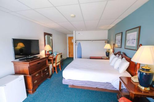 Habitación de hotel con cama y TV de pantalla plana. en Boothbay Harbor Inn, en Boothbay Harbor