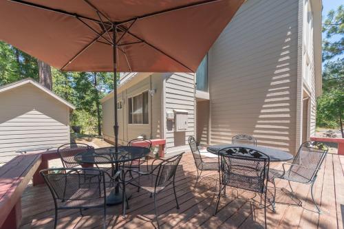 a patio with two tables and chairs and an umbrella at Pinecone Peak in Dorrington