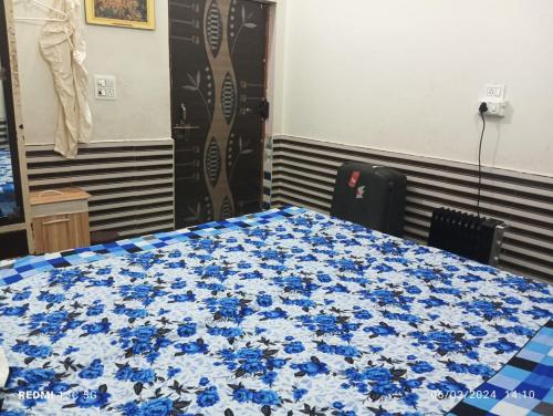 a table with blue flowers on it in a room at RADHA NIVAS in Govardhan