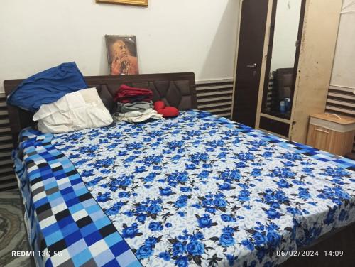 a bed with a blue and white quilt on it at RADHA NIVAS in Govardhan