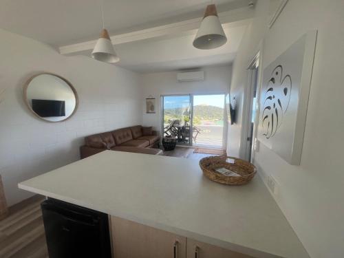 a kitchen with a counter top and a living room at Ranui Lodge in Mangonui