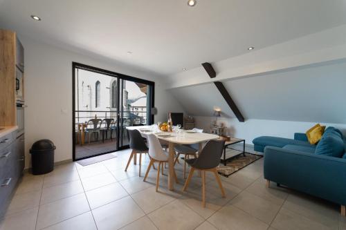 un salon avec une table et un canapé bleu dans l'établissement Le Roc du Cygne charmant appartement 4 personnes à deux pas du lac, à Duingt